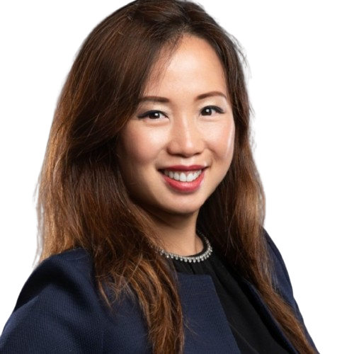 A woman with long brown hair is smiling, wearing a navy blazer and a black top.